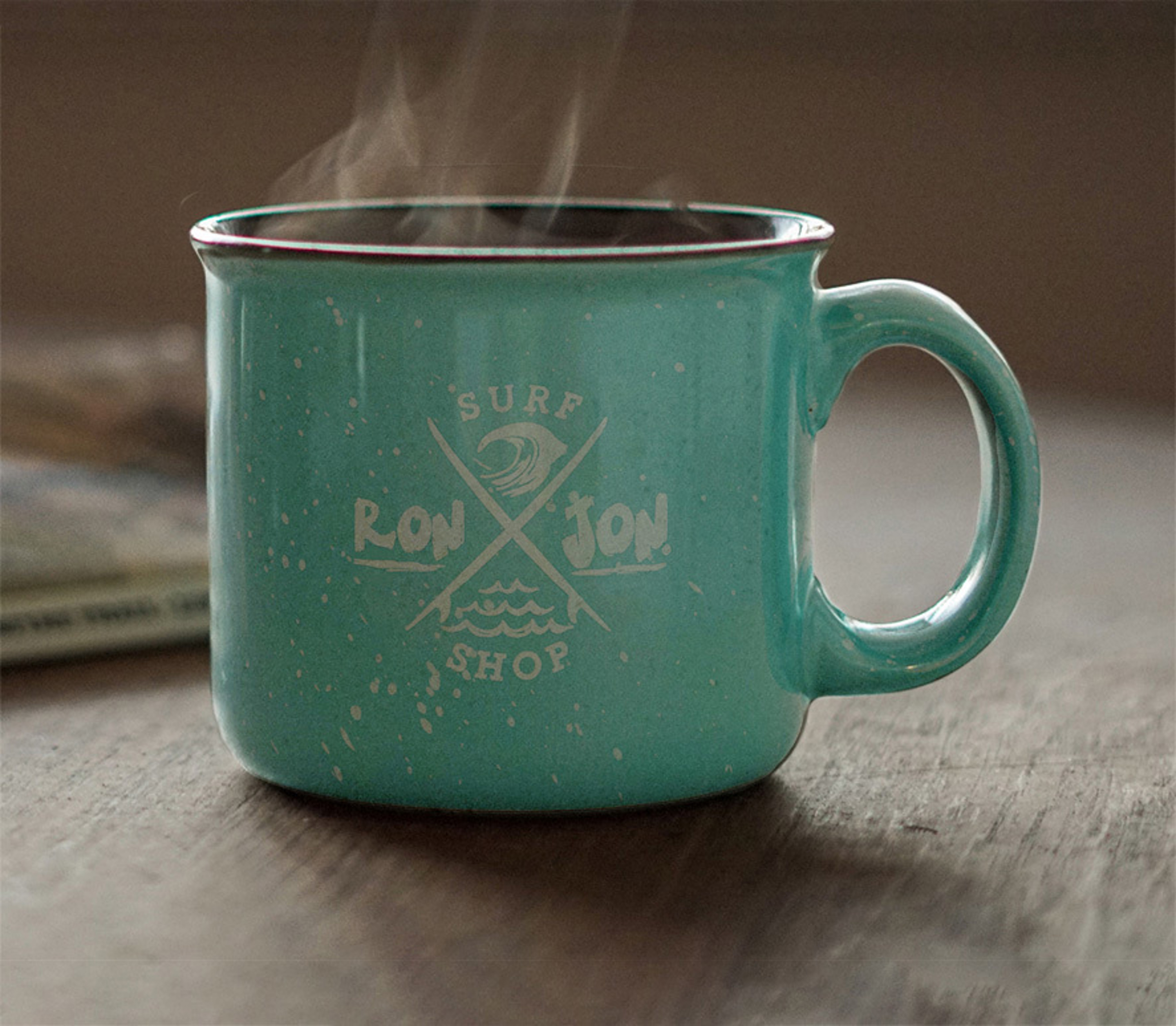 Camp style ceramic mug with Ron Jon Surf Shop lettering with steam coming off the beverage within