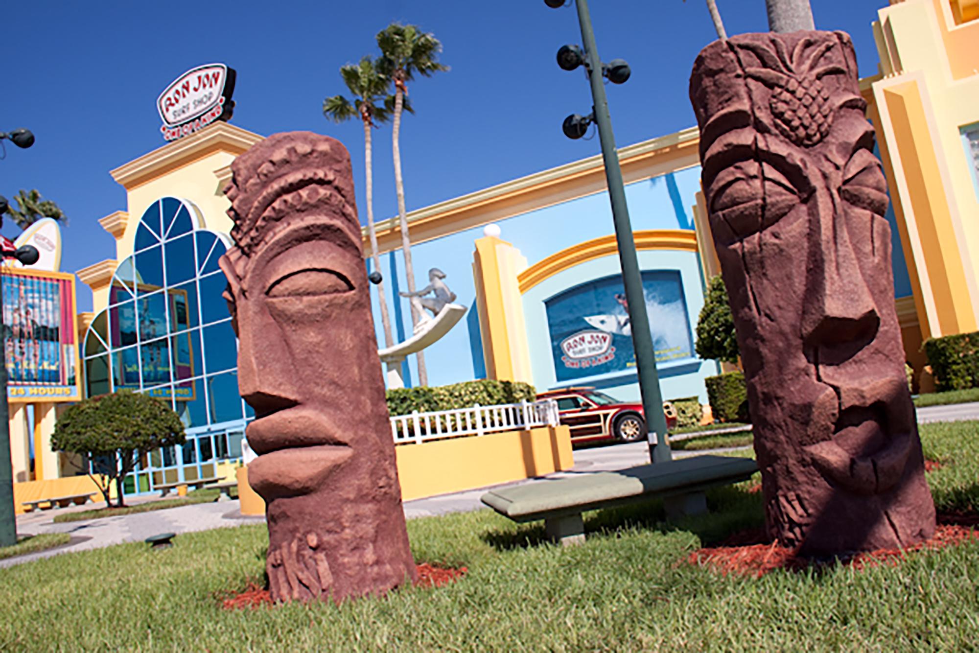 Photo of exterior of the Ron Jon Surf Shop in Cocoa Beach with tikis in front